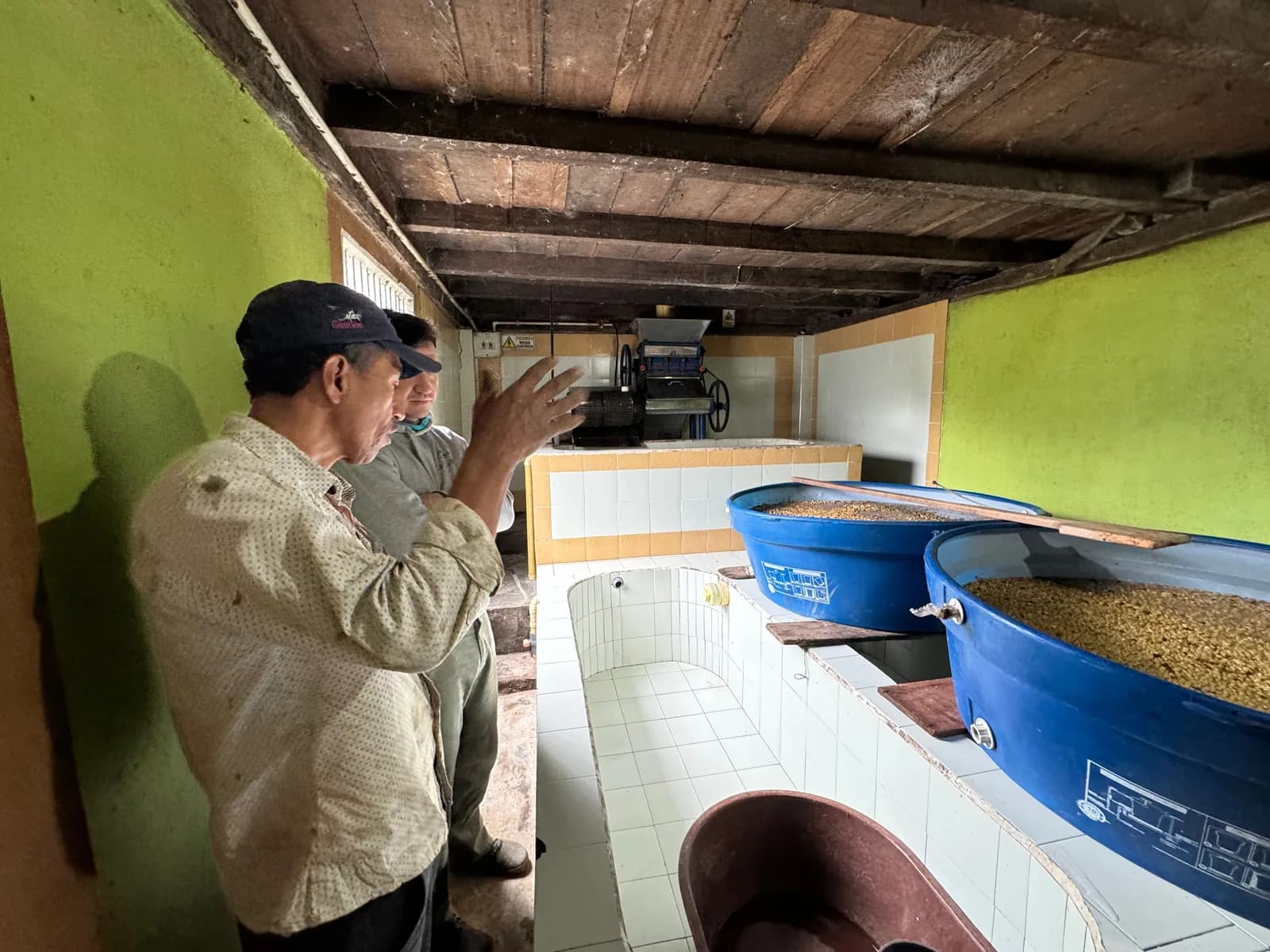 Friedhats brand image: Two people talking through coffee processing at a farm
