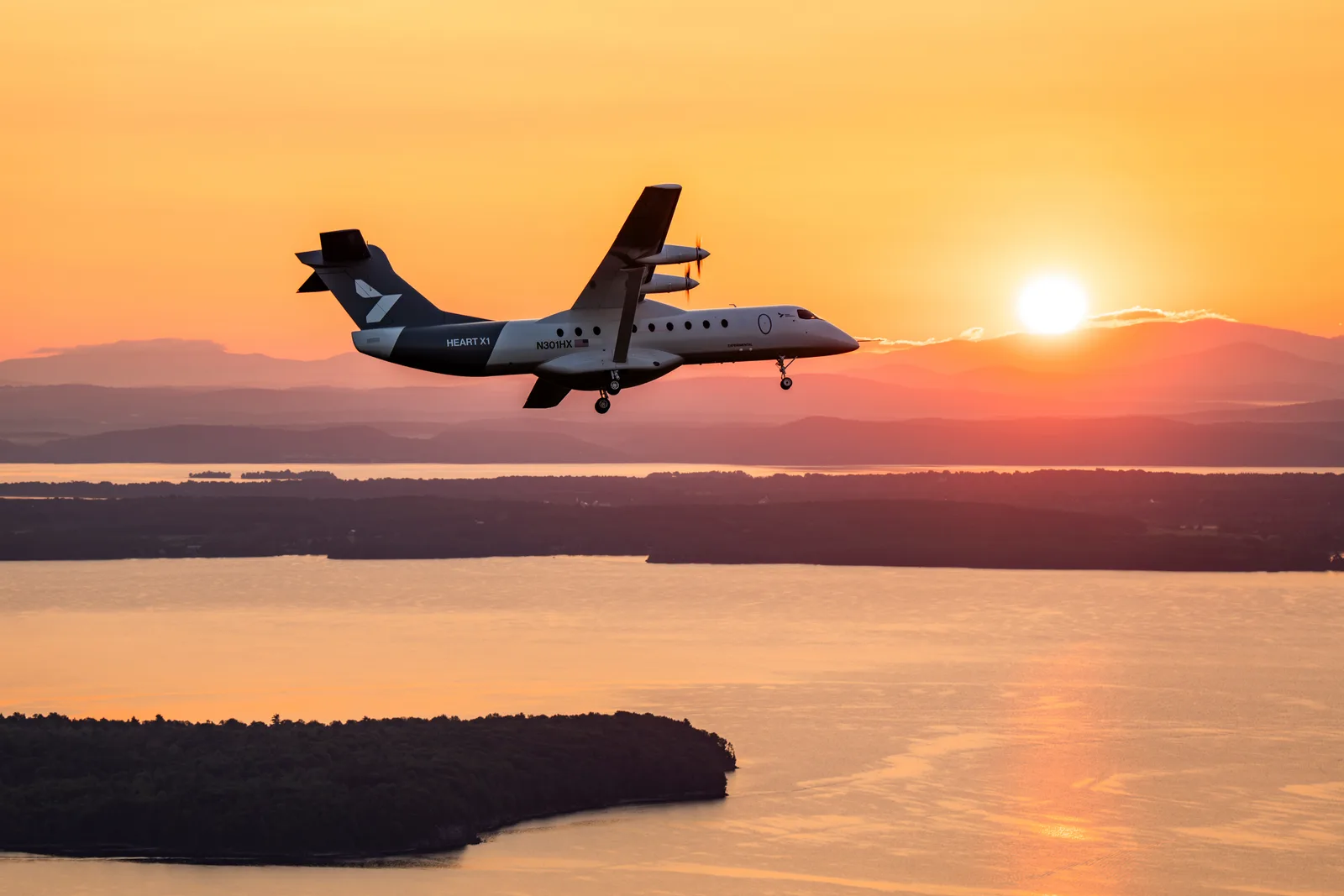 Brief image: X1 banking east toward the rising sun, Lake Champlain beyond