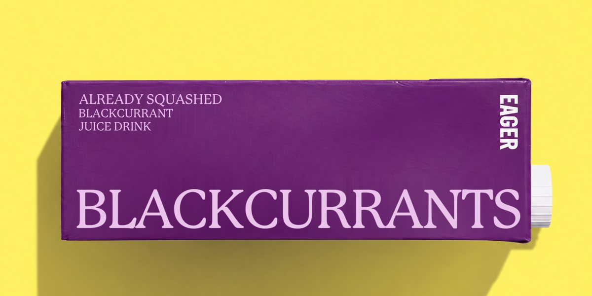 A purple Eager carton lying on yellow: BLACKCURRANTS, already squashed blackcurrant juice drink.